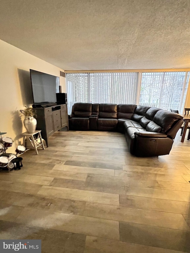 unfurnished living room featuring a textured ceiling and light wood-type flooring