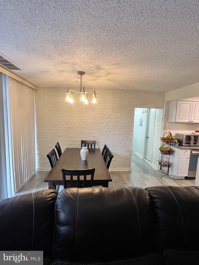 dining space featuring light wood-type flooring and a notable chandelier