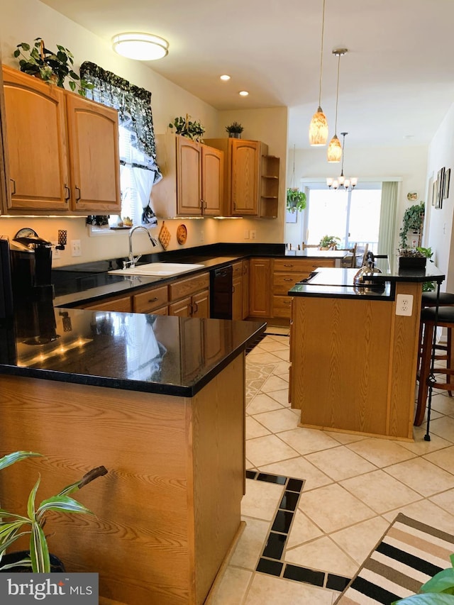 kitchen with sink, light tile patterned flooring, hanging light fixtures, a kitchen island, and a chandelier