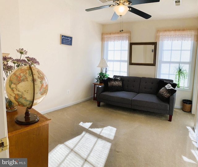 living room with light colored carpet, ceiling fan, and a healthy amount of sunlight