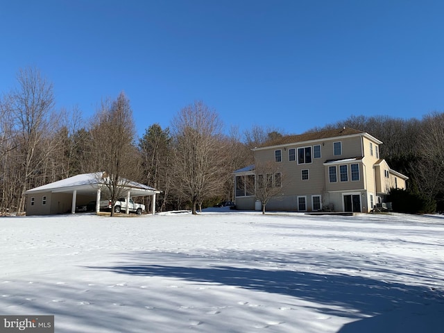 view of snow covered back of property