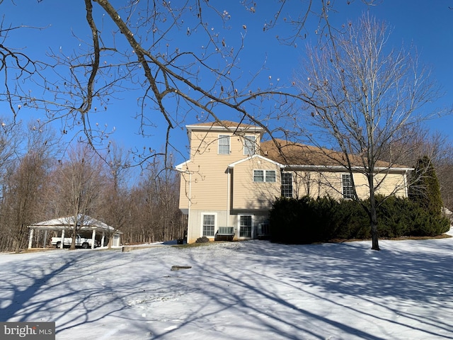 view of snowy exterior featuring a carport