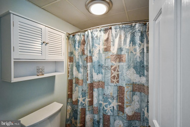 bathroom with a shower with shower curtain and toilet