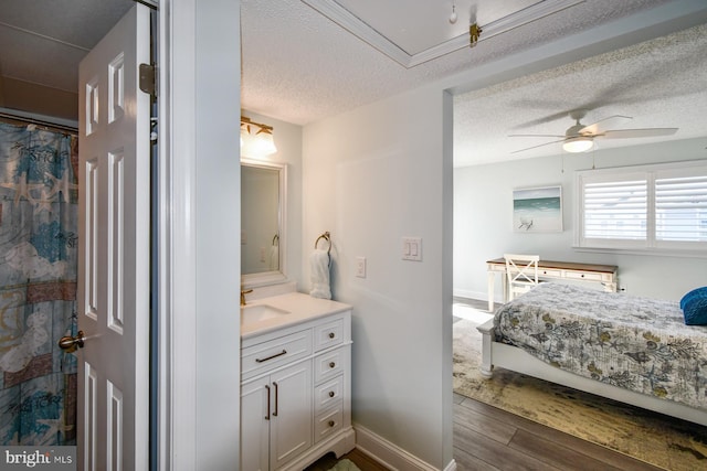 bathroom with vanity, hardwood / wood-style floors, a textured ceiling, and ceiling fan