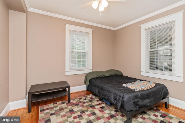 bedroom with ceiling fan, ornamental molding, and wood-type flooring