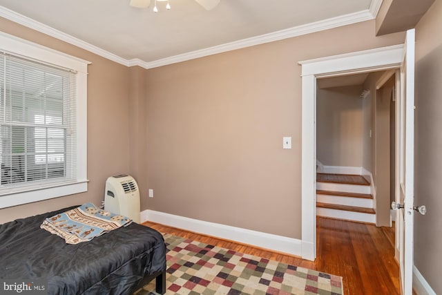 bedroom with ceiling fan, dark hardwood / wood-style flooring, and ornamental molding