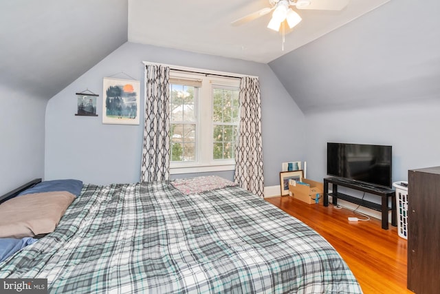 bedroom with ceiling fan, lofted ceiling, and hardwood / wood-style flooring