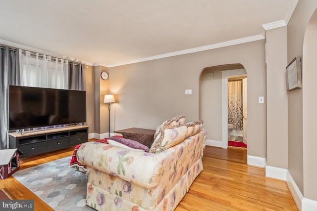 living room with light wood-type flooring and crown molding