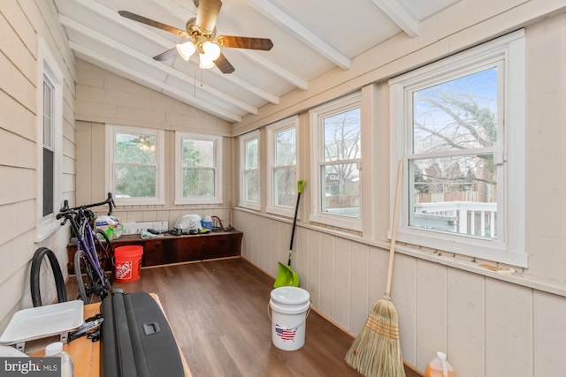 sunroom with ceiling fan, plenty of natural light, and vaulted ceiling with beams