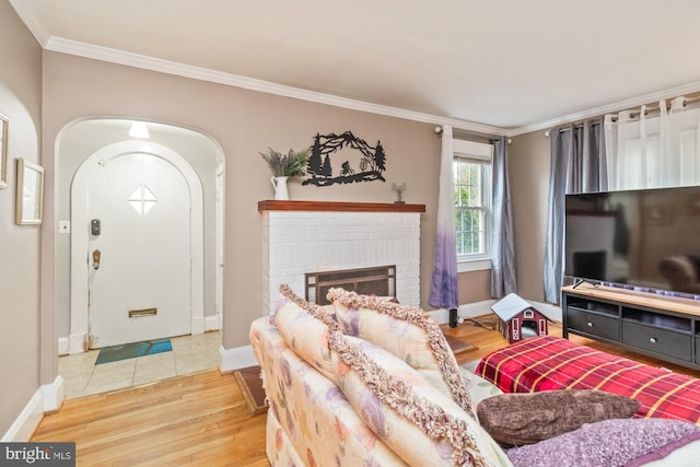 living room featuring a brick fireplace, hardwood / wood-style floors, and ornamental molding