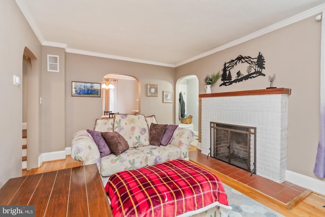 living room with hardwood / wood-style floors, ornamental molding, and a fireplace