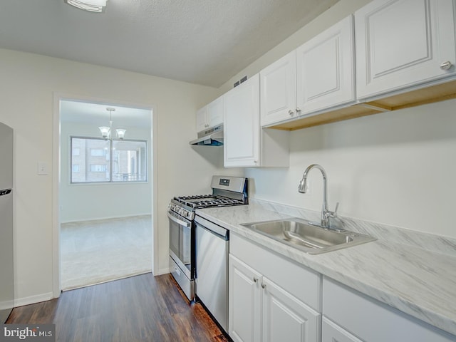 kitchen featuring dark hardwood / wood-style flooring, stainless steel appliances, sink, white cabinets, and a chandelier