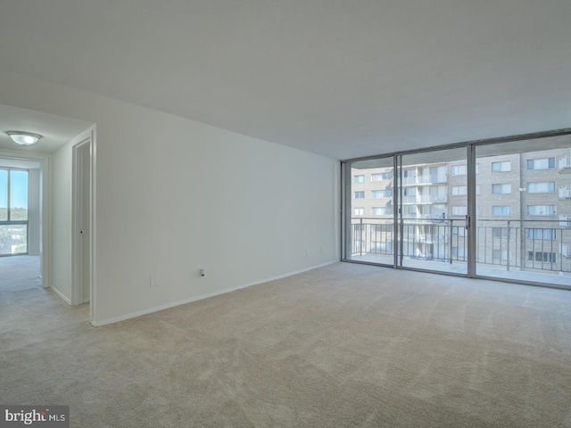 carpeted empty room featuring floor to ceiling windows