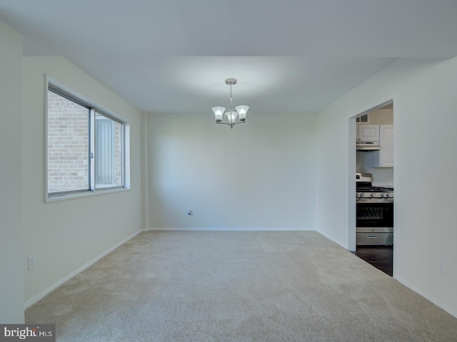 empty room featuring carpet floors and an inviting chandelier