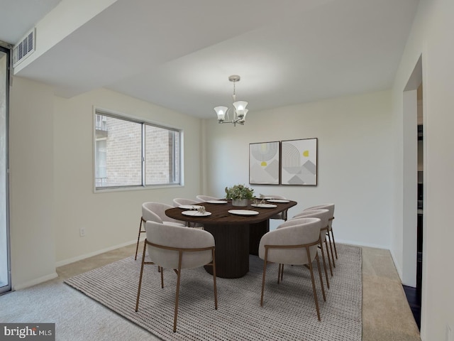 carpeted dining area featuring a notable chandelier