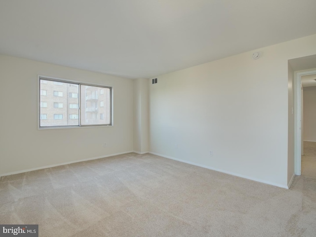 unfurnished room featuring light carpet