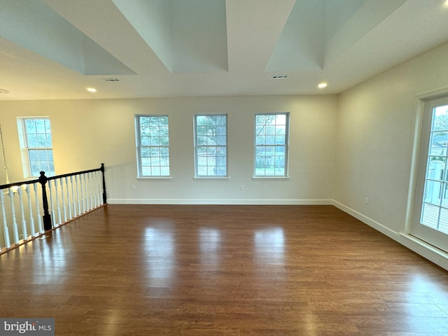 unfurnished room featuring dark hardwood / wood-style flooring and a wealth of natural light