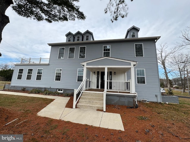 colonial-style house with covered porch and a front yard