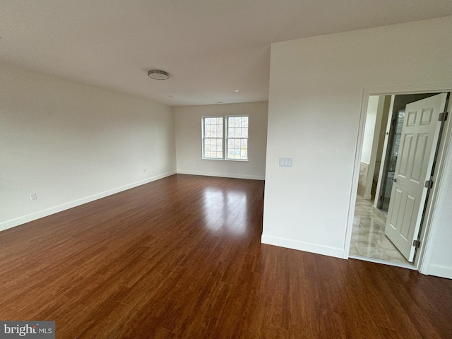 unfurnished room with dark wood-type flooring