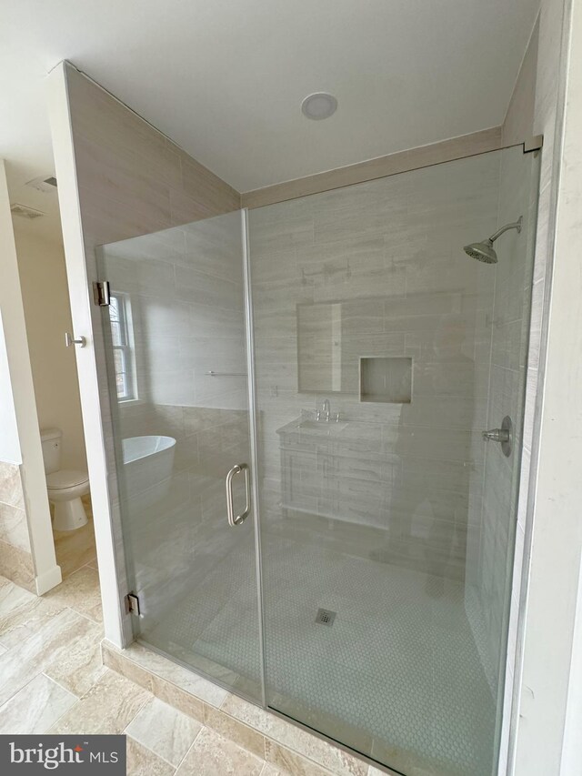 bathroom with an enclosed shower and toilet