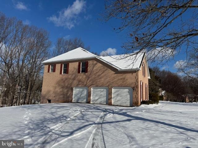 view of snow covered exterior with a garage