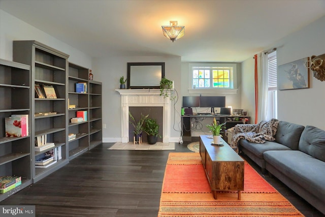 living room with baseboards, a fireplace with flush hearth, and wood finished floors