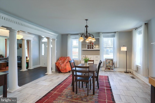 dining area featuring tile patterned floors, baseboards, and ornate columns