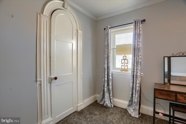 bedroom featuring baseboards, dark carpet, and crown molding