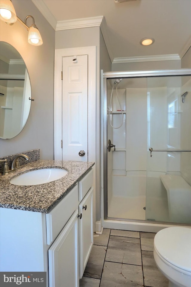 full bathroom featuring a stall shower, toilet, ornamental molding, and vanity