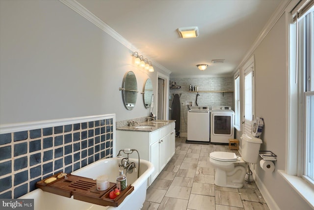 full bath with vanity, a soaking tub, separate washer and dryer, a tile shower, and ornamental molding