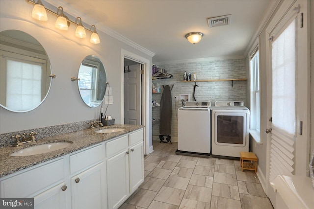 laundry area with washer and dryer, visible vents, laundry area, and a sink