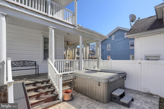 view of patio / terrace with a hot tub and fence