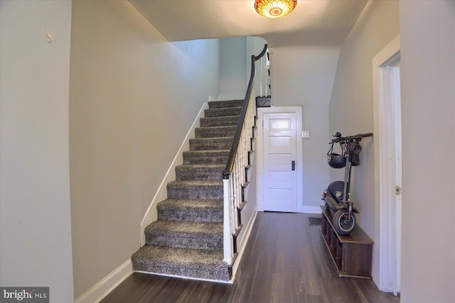 stairway with baseboards and wood finished floors