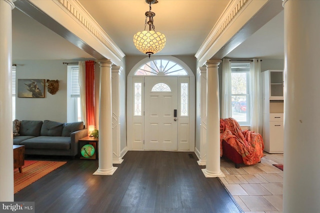 foyer featuring decorative columns and wood finished floors