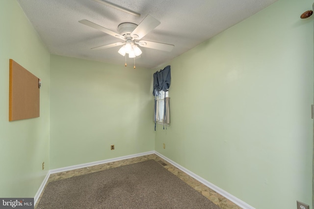 spare room with a textured ceiling, a ceiling fan, and baseboards