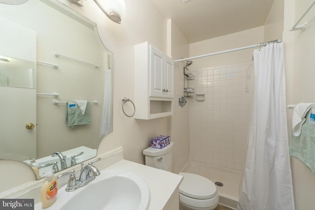 bathroom with toilet, a shower stall, and vanity