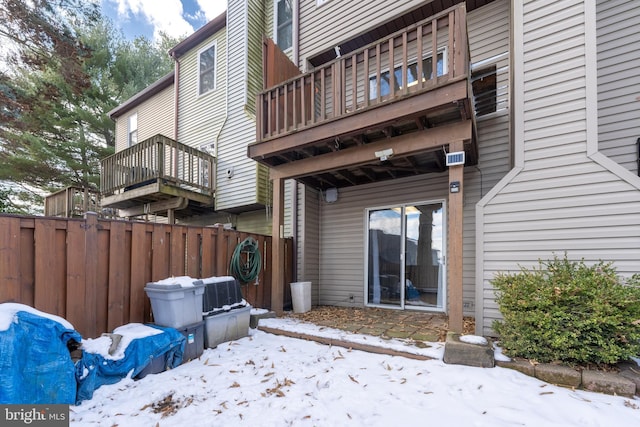 snow covered property featuring fence and a deck