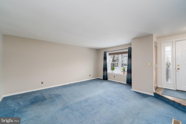 interior space with dark colored carpet, visible vents, and baseboards