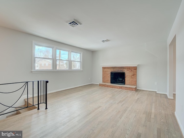 unfurnished living room with a fireplace and light hardwood / wood-style flooring