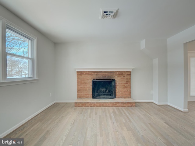 unfurnished living room with a fireplace and light hardwood / wood-style flooring