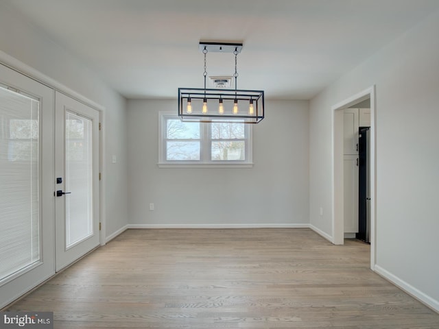 unfurnished dining area featuring french doors and light hardwood / wood-style floors