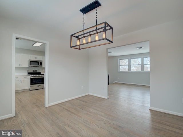 interior space with a notable chandelier and light hardwood / wood-style flooring