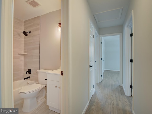 full bathroom featuring toilet, hardwood / wood-style flooring, tiled shower / bath, and vanity