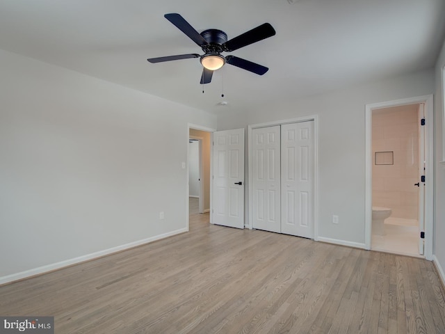 unfurnished bedroom featuring ceiling fan, light wood-type flooring, ensuite bathroom, and a closet