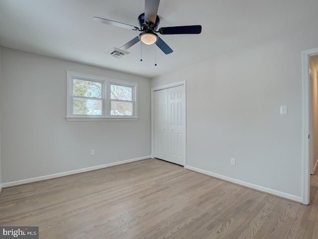 unfurnished bedroom with ceiling fan, light hardwood / wood-style flooring, and a closet