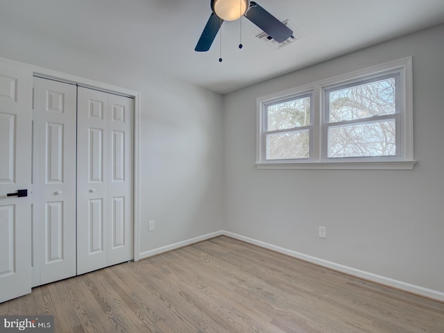 unfurnished bedroom with ceiling fan, light hardwood / wood-style floors, and a closet