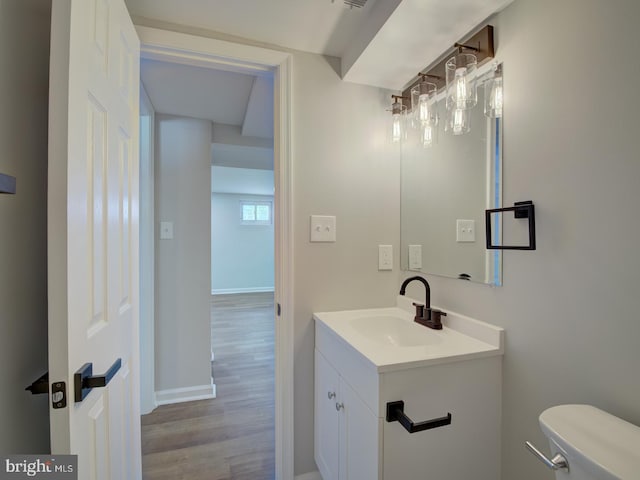 bathroom with hardwood / wood-style floors, vanity, and toilet