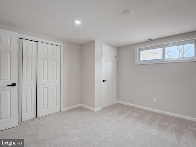 unfurnished bedroom featuring light colored carpet and a closet