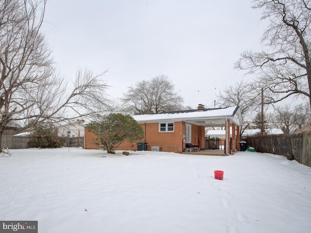 view of snow covered back of property