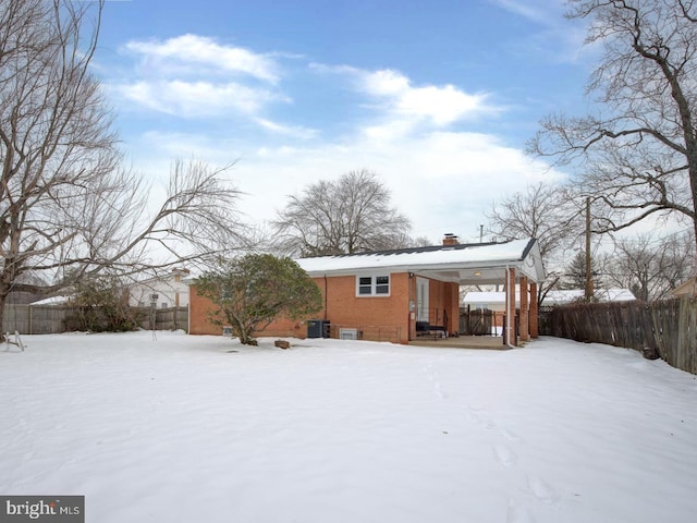 view of snow covered rear of property